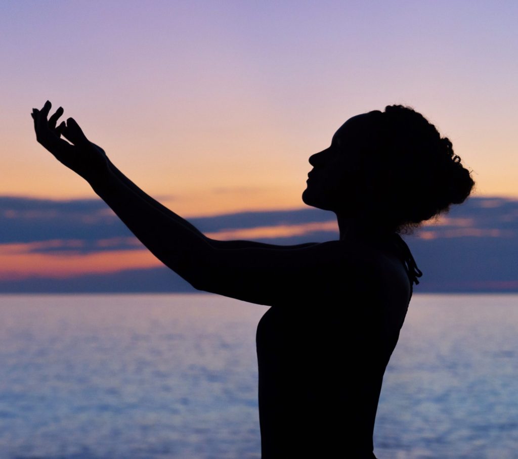 silhouette of woman raising her right hand